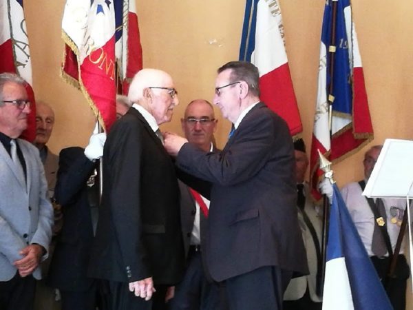 Guy Darmanin, président national de la FNACA, remet l'insigne de l'Ordre National du Mérite à Roger Toullec