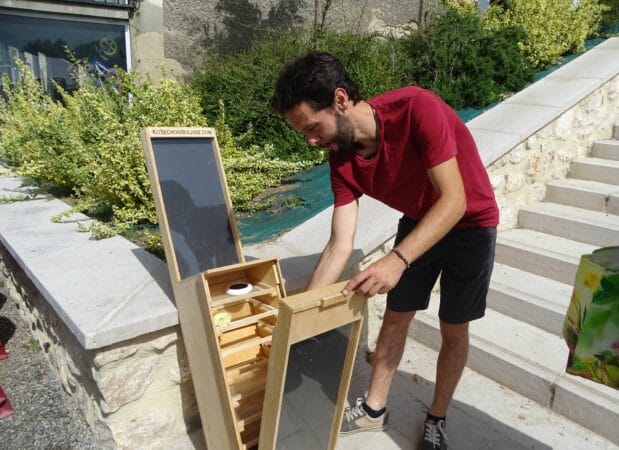 Laurent Lafforgue en démonstration avec un séchoir solaire à fruits et légumes artisanal.