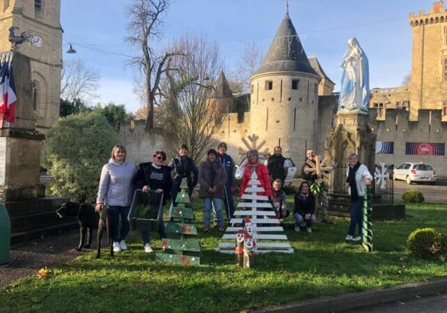 Le village arbore les décorations et illuminations de Noël, grâce aux bénévoles qui ont aidé à les fabriquer et à les poser. (I. Huppert maire et les bénévoles devant le château)