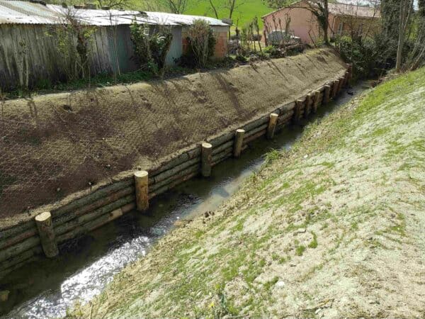 Le talus végétalisé et la palissade qui contiendront les crues du ruisseau La Magdelaine.