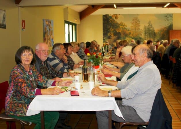 Anne-Marie Vecchiutti, présidente de la Belote Gourmande et les participants dégustant la fricassée.