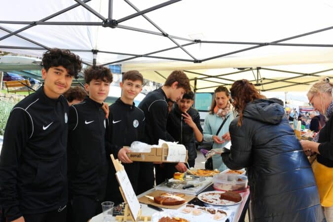 Les jeunes footballeurs d'Aurignac sur la marché, pour vendre des pâtisseries et financer leur voyage à Valras.