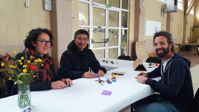 Le stand d'origami avec Nori Naeda, à la Fête du Printemps à Castelnau (à g Coline Docet-Moreau, à dr Eric Docet)