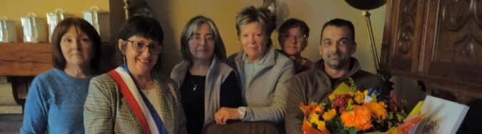 Le Conseil Municipal venu honorer la doyenne du village, chargé de fleurs et cadeau,