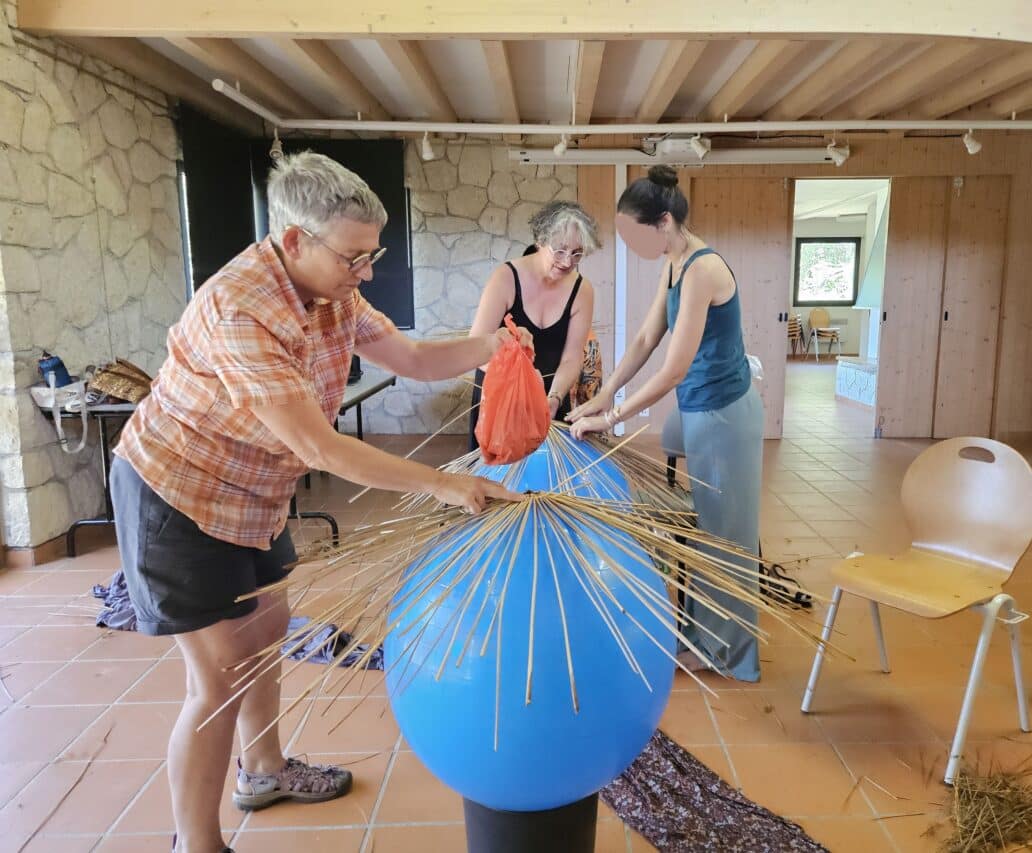 Un abat-jour en jonc, une réalisation en vannerie sauvage à l'arboretum avec Patricia Brangeon (au centre).